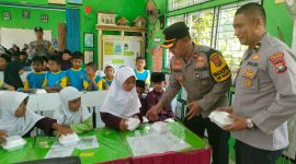 Wakapolres Karimun Kompol Herie Pramono membagikan makan siang gratis kepada siswa SDN 011 Tebing. Foto: Dokumen Polsek Tebing