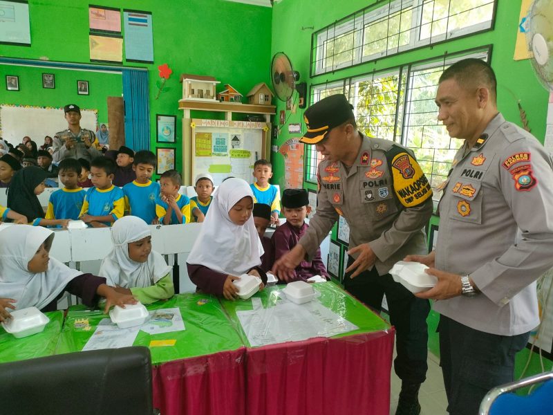 Wakapolres Karimun Kompol Herie Pramono membagikan makan siang gratis kepada siswa SDN 011 Tebing. Foto: Dokumen Polsek Tebing