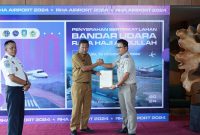 Kepala BPN Karimun Benny Ryanto menyerahkan sertipikat lahan bandara RHA ke PLT Sekda Kabupaten Karimun Djunaidy dengan disaksikan Kabandara RHA Karimun Fanani Zuhri. Foto: Istimewa