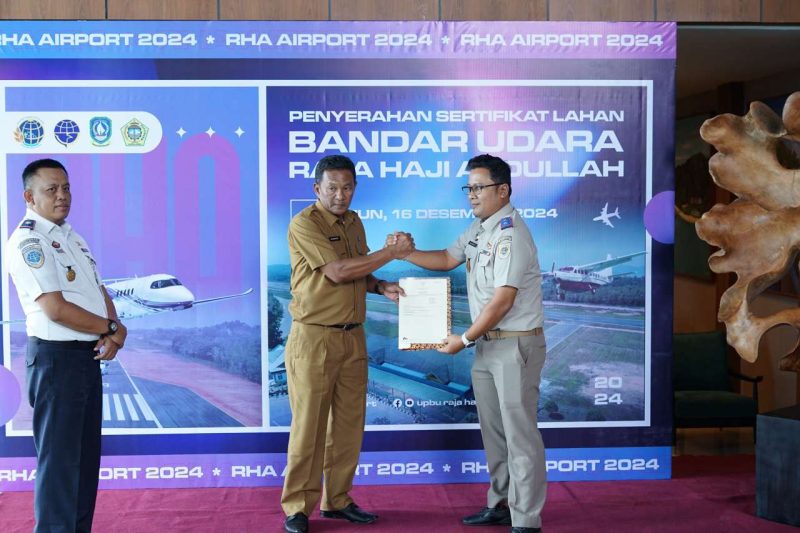 Kepala BPN Karimun Benny Ryanto menyerahkan sertipikat lahan bandara RHA ke PLT Sekda Kabupaten Karimun Djunaidy dengan disaksikan Kabandara RHA Karimun Fanani Zuhri. Foto: Istimewa