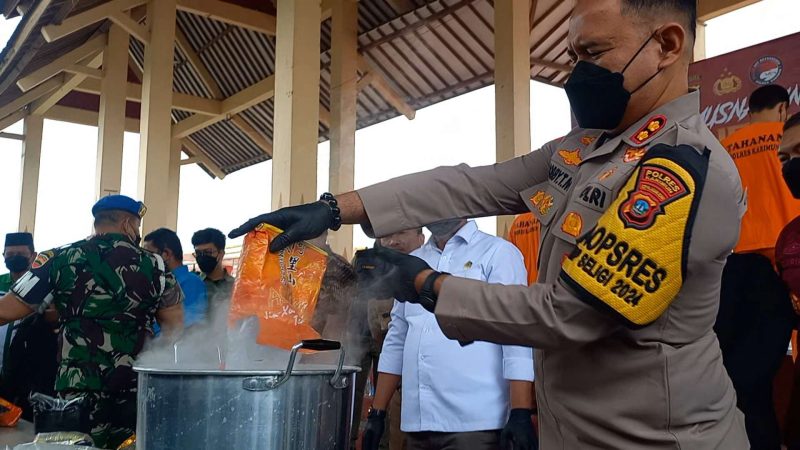 Kapolres Karimun AKBP Robby Topan Manusiwa menuangkan sabu ke dalam panci berisi air panas. Foto: ricky/kepriheadline.id 