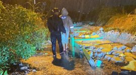Personil Polsek Tebing membersihkan reruntuhan pagar TPU yang longsor akibat hujan deras. Foto: Istimewa