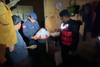 Anggota Brimob dibawah pimpinan Danki 2 Yon A Pelopor, IPDA A.Z.E. memindahkan barang-barang berharga milik korban banjir. Foto: istimewa