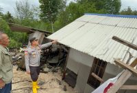 Kapolsek Tebing AKP Binsar Samosir meninjau kondisi rumah ambruk pasca terkena abrasi air laut. Foto: istimewa/Kepriheadline.id 