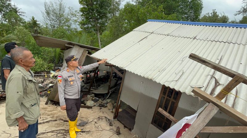 Kapolsek Tebing AKP Binsar Samosir meninjau kondisi rumah ambruk pasca terkena abrasi air laut. Foto: istimewa/Kepriheadline.id 