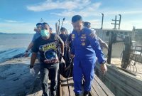 Polisi mengevakuasi jasad seorang pria yang ditemukan di pesisir Kamkong, Kecamatan Meral. FOTO: Istimewa