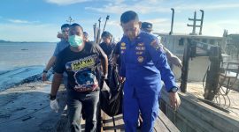 Polisi mengevakuasi jasad seorang pria yang ditemukan di pesisir Kamkong, Kecamatan Meral. FOTO: Istimewa