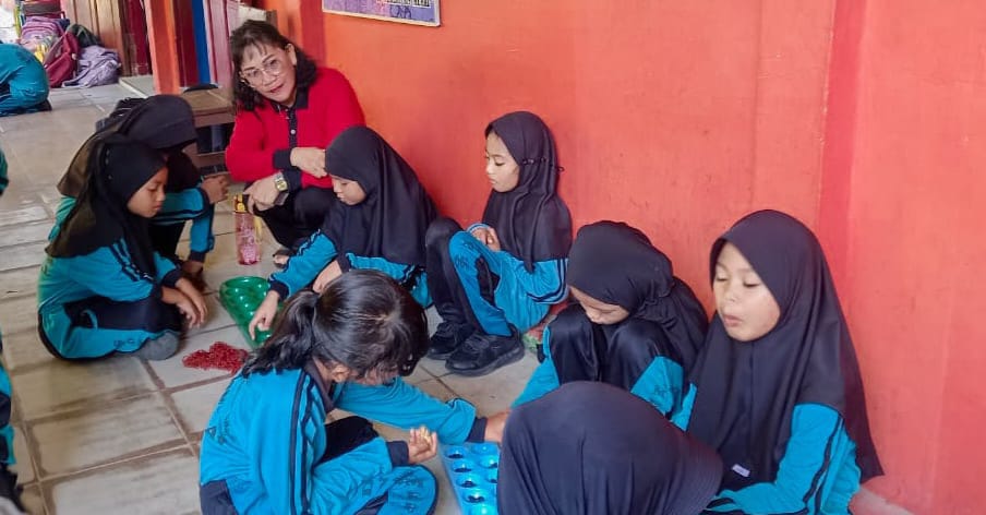 Anak- anak SD 009 Meral bermain permainan tradisional Congklak. FOTO: Istimewa