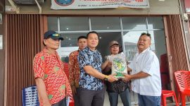 Ketua Panitia Bakti Sosial Binsar Samosir menyerahkan secara simbolis bantuan paket beras kepada perwakilan penyalur. 