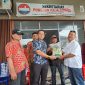 Ketua Panitia Bakti Sosial Binsar Samosir menyerahkan secara simbolis bantuan paket beras kepada perwakilan penyalur. 