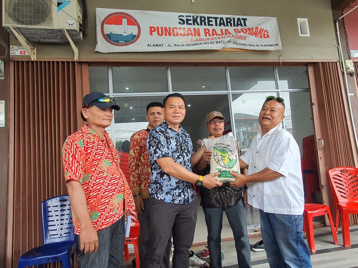 Ketua Panitia Bakti Sosial Binsar Samosir menyerahkan secara simbolis bantuan paket beras kepada perwakilan penyalur. 