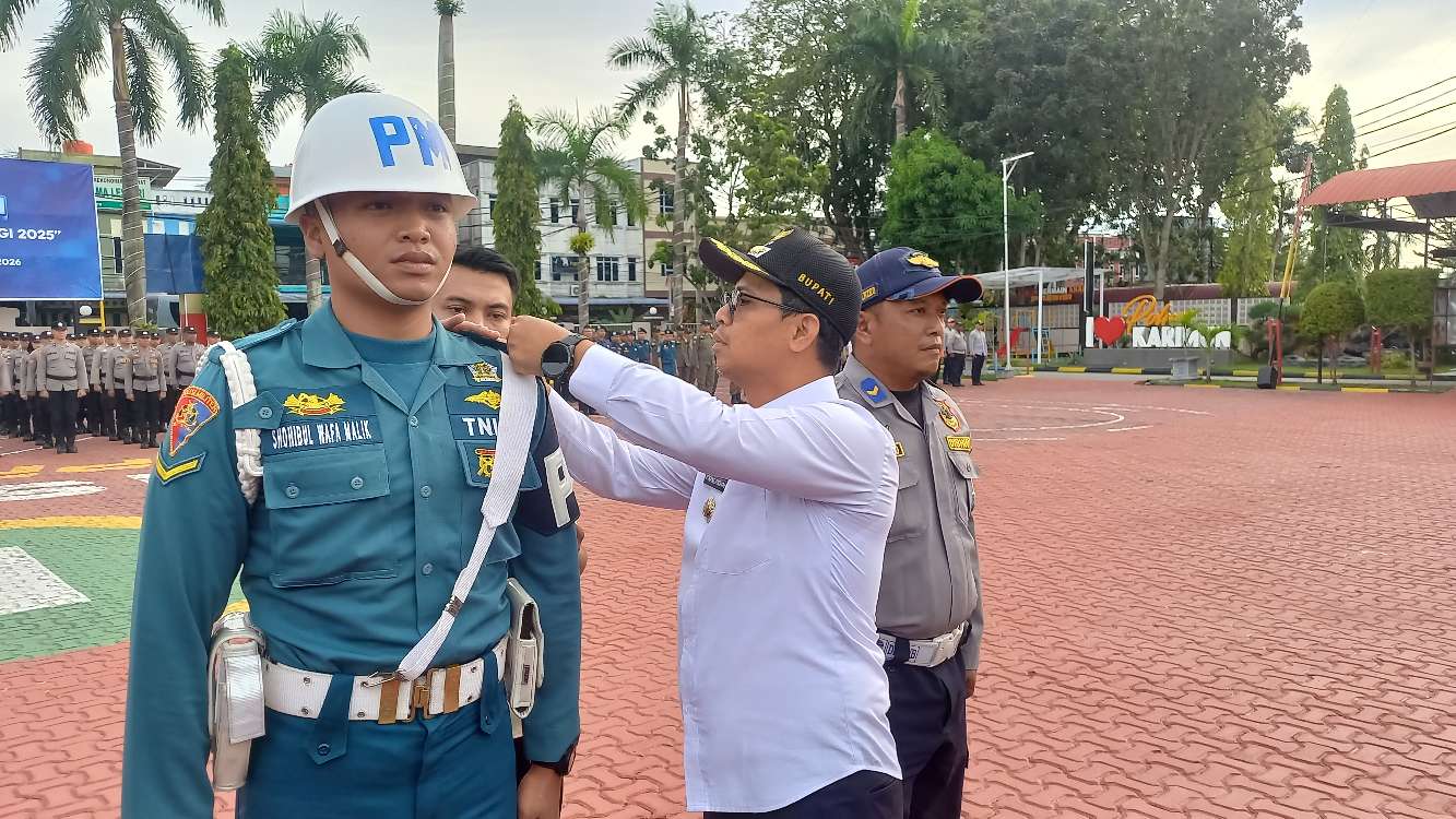 Bupati Karimun Iskandarsyah menyematkan Pita Tanda Operasi Lilin Seligi 2025 saat Apel Gelar Pasukan di Mapolres Karimun. FOTO: ricky/kepriheadline.id