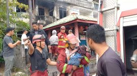 Petugas damkar Karimun mengevakuasi dua orang balita korban kebakaran di Karimun.