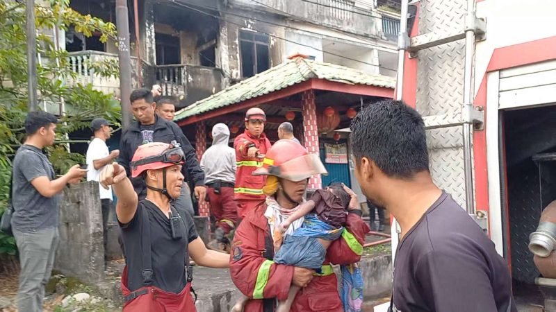 Petugas damkar Karimun mengevakuasi dua orang balita korban kebakaran di Karimun.