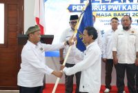 Ketua Terpilih PWI Karimun Periode 2026-2029 menerima penyerahan Pataka dari Ketua PWI Kepri Saibansah Dardani.